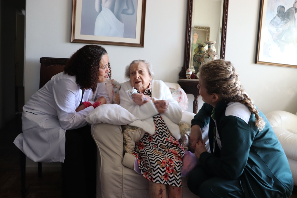 Dona Otília recebendo visita do programa Unimed Lar