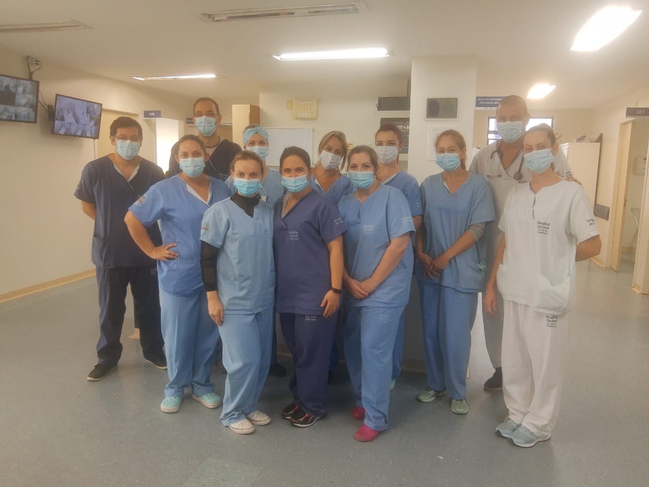 Foto mostra Joice e colegas da UTI de Covid com uniformes no corredor do hospital