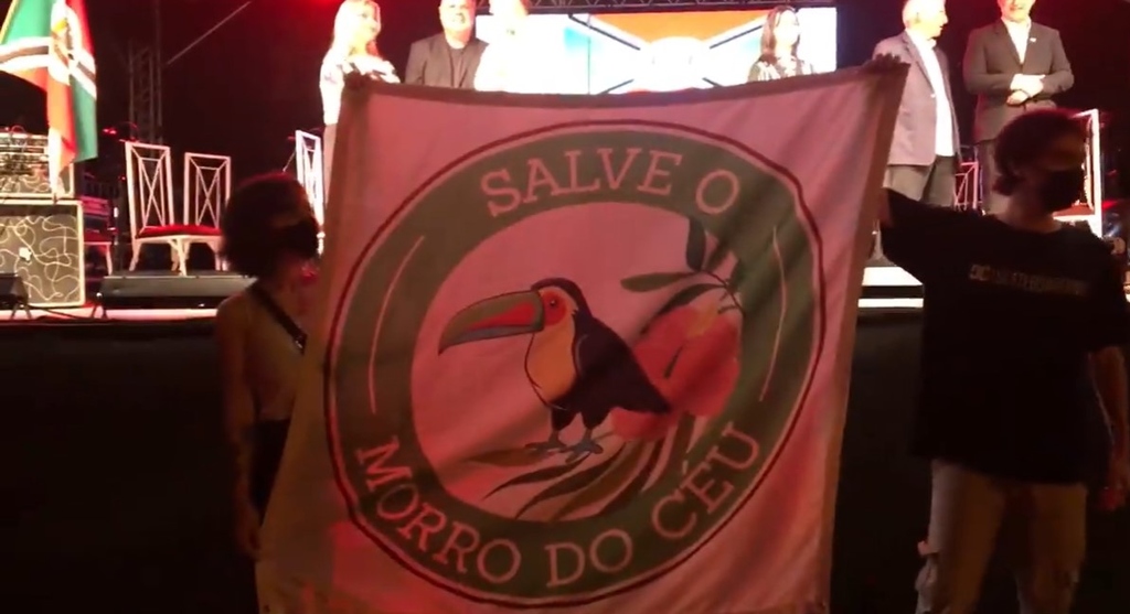 Faixa estendida diante do prefeito durante o evento de sexta-feira Faixa estendida diante do prefeito durante o evento de sexta-feira
