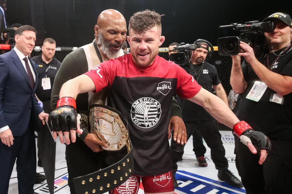 Natan recebe o cinturão das mãos de Mike Tyson