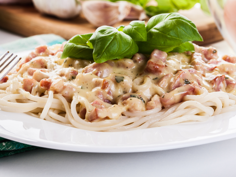 Macarrão com bacon e molho branco Macarrão com molho branco e bacon em prato branco