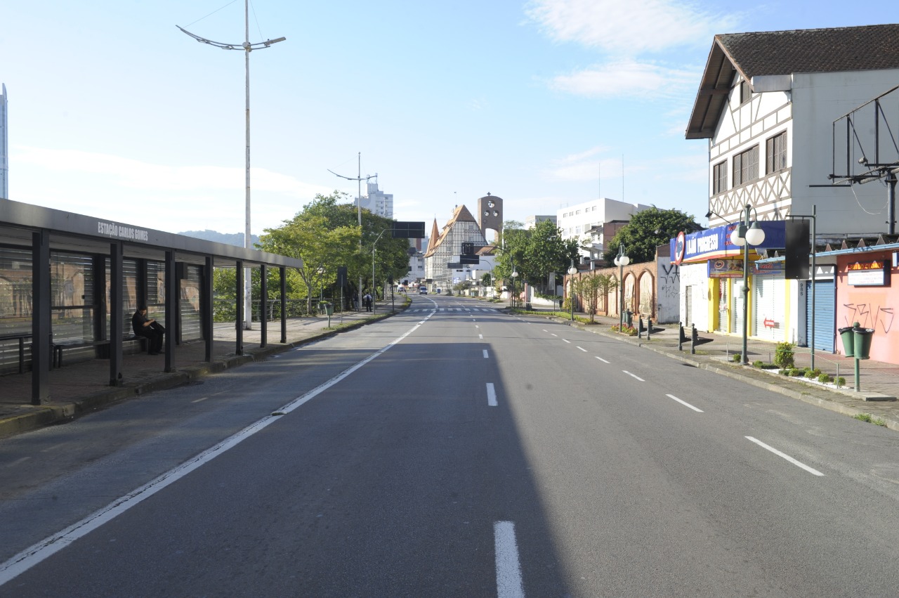 Na Avenida Beira-Rio, um homem aguardava sentado no abrigo de ônibus em meio à rua vazia.
