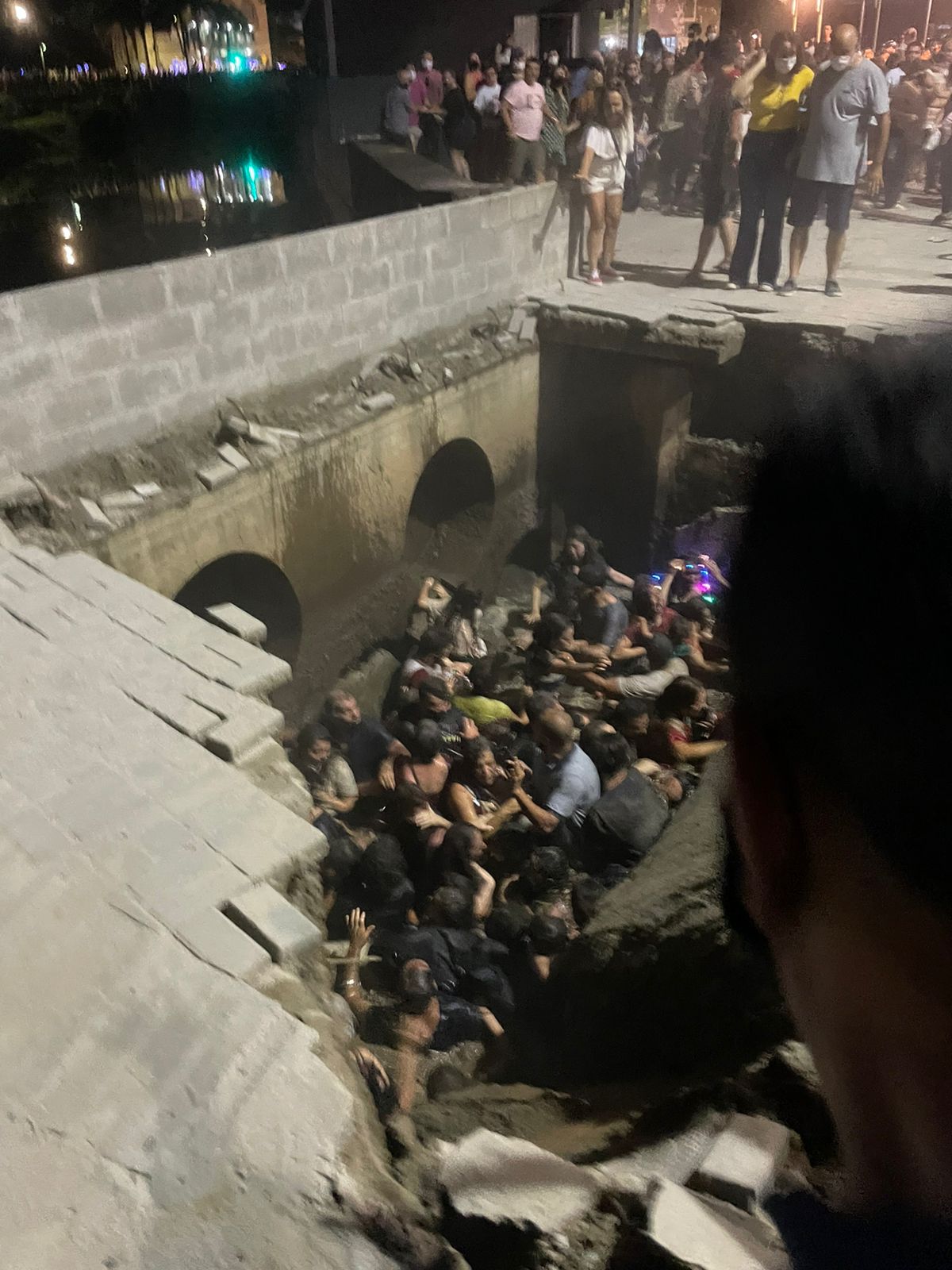 Imagens que circulam nas redes sociais mostram cerca de 20 pessoas dentro do rio após a queda, entre elas, crianças e adultos.